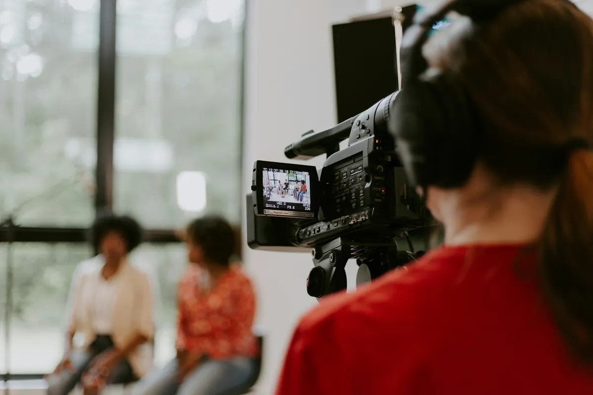 Une opératrice filme deux femmes assises pendant une interview